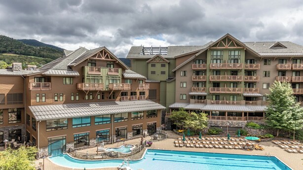 A resort with multiple buildings, a swimming pool, and outdoor seating areas.