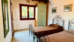 A bedroom with two beds, a wardrobe, a window, and a door. - Shardana 2 (San Teodoro)