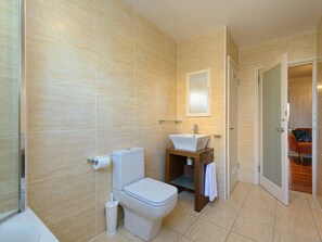 A modern bathroom with a toilet, sink, and mirror. - Corrin - Chic 1 Bedroom Apartment (North Berwick)