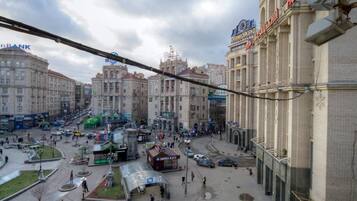 Un hotel con un cartel grande, una plaza central con parada de autobús y edificios circundantes con diversos letreros.