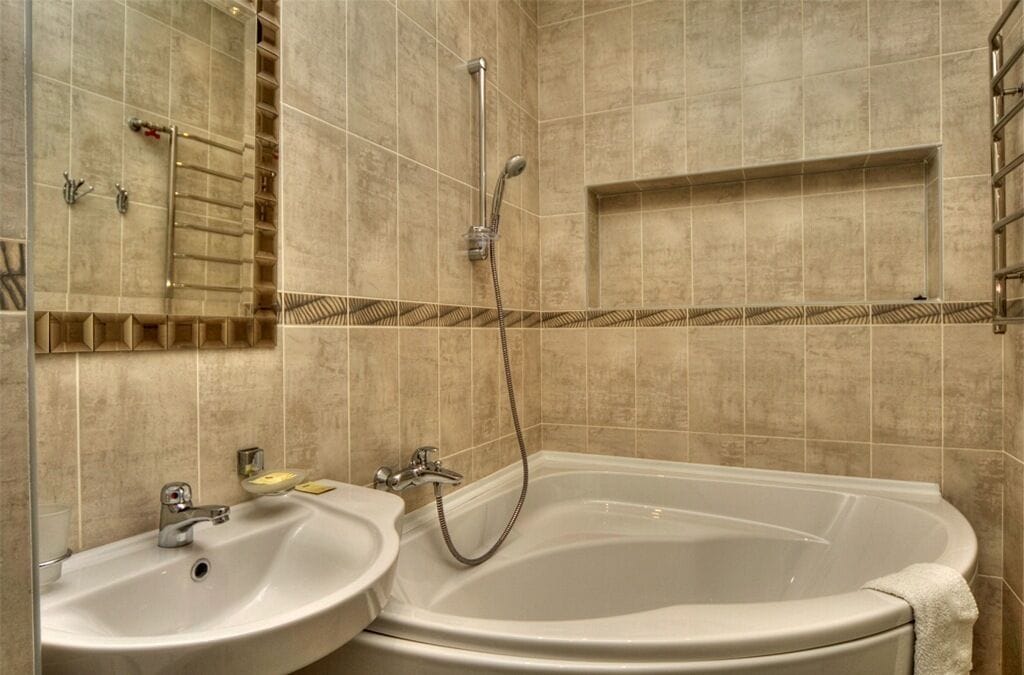 A bathroom with a bathtub, two sinks, and a shower.