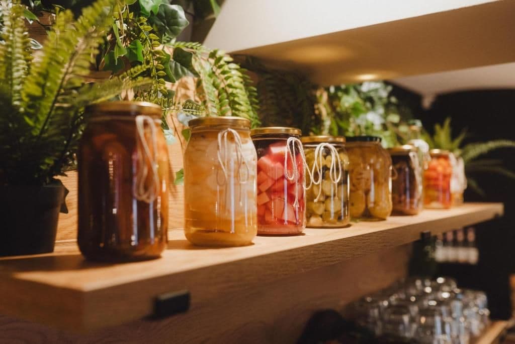 Une étagère avec des bocaux contenant des aliments conservés.