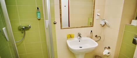 Une salle de bain avec une douche, un lavabo et des toilettes.