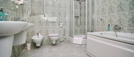 Un baño con ducha, bidé y bañera.