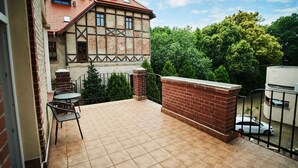 Un patio con suelo de baldosas, pared de ladrillo y valla de metal.