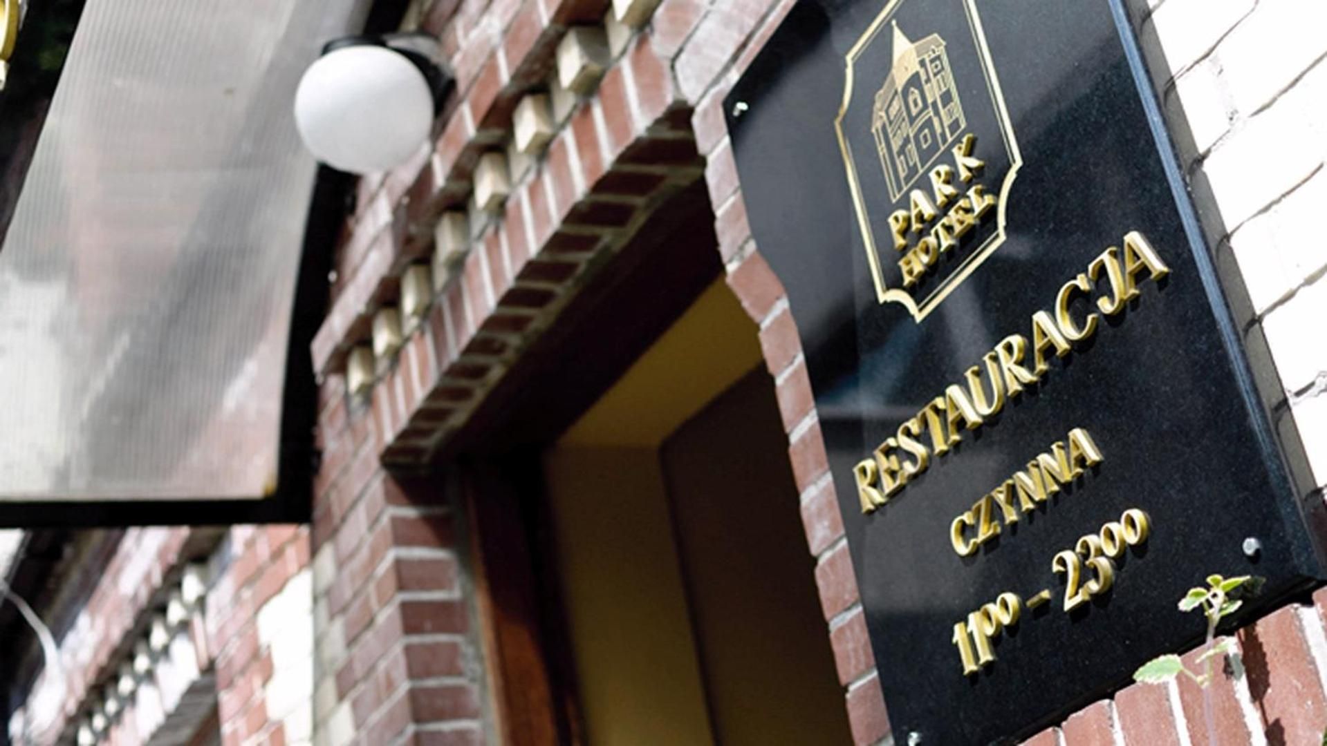 A black sign with gold lettering for Park Hotel, indicating the name and address.