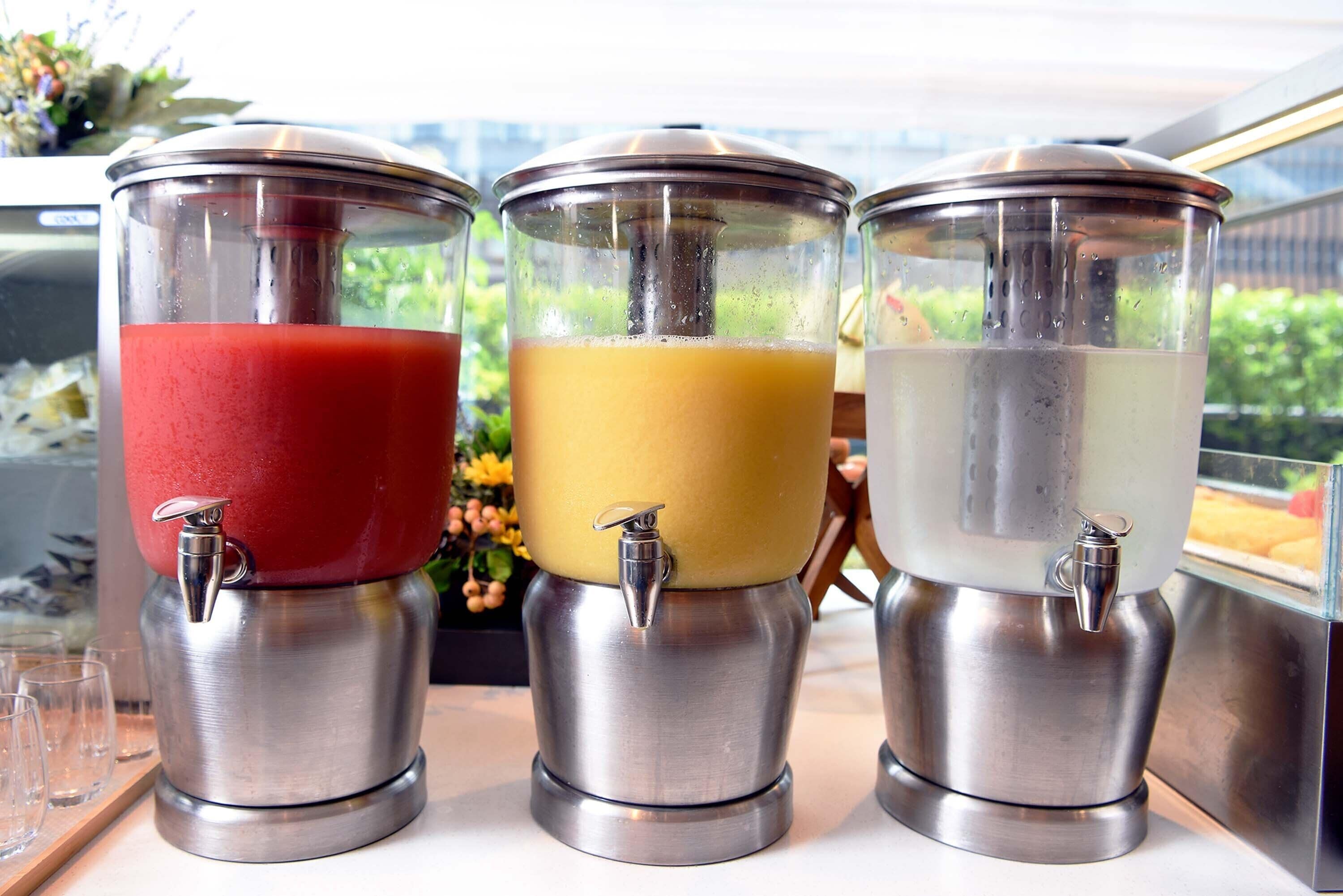 Three beverage dispensers with different colored liquids.