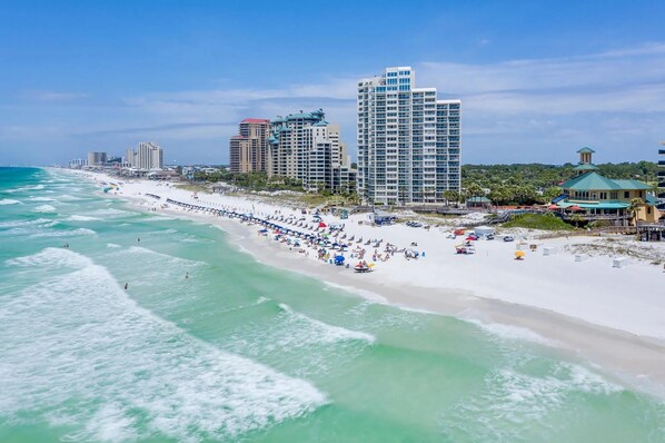 A beach with a long pier, several high-rise buildings, and a clear blue sky. - Complimentary LSV (Golf Cart)⛳-Screened Deck-4BR Thirsty Turtle (Sandestin Beach and Golf Resort , Miramar Beach)