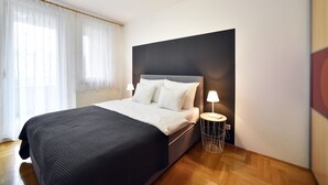 Ein modernes Schlafzimmer mit einem großen Bett, weißer Bettwäsche und zwei Nachttischlampen.