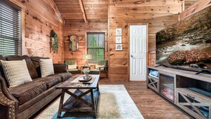 Ambiente in legno con divano, tavolino e mobile TV.