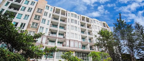 A multi-story hotel with balconies, a courtyard, and a mix of brick and white exterior walls.