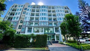 A multi-story hotel with a modern design, featuring balconies on each floor and a central entrance. - Fortune Courtyard Khao Yai Hotel Official (Pak Chong)