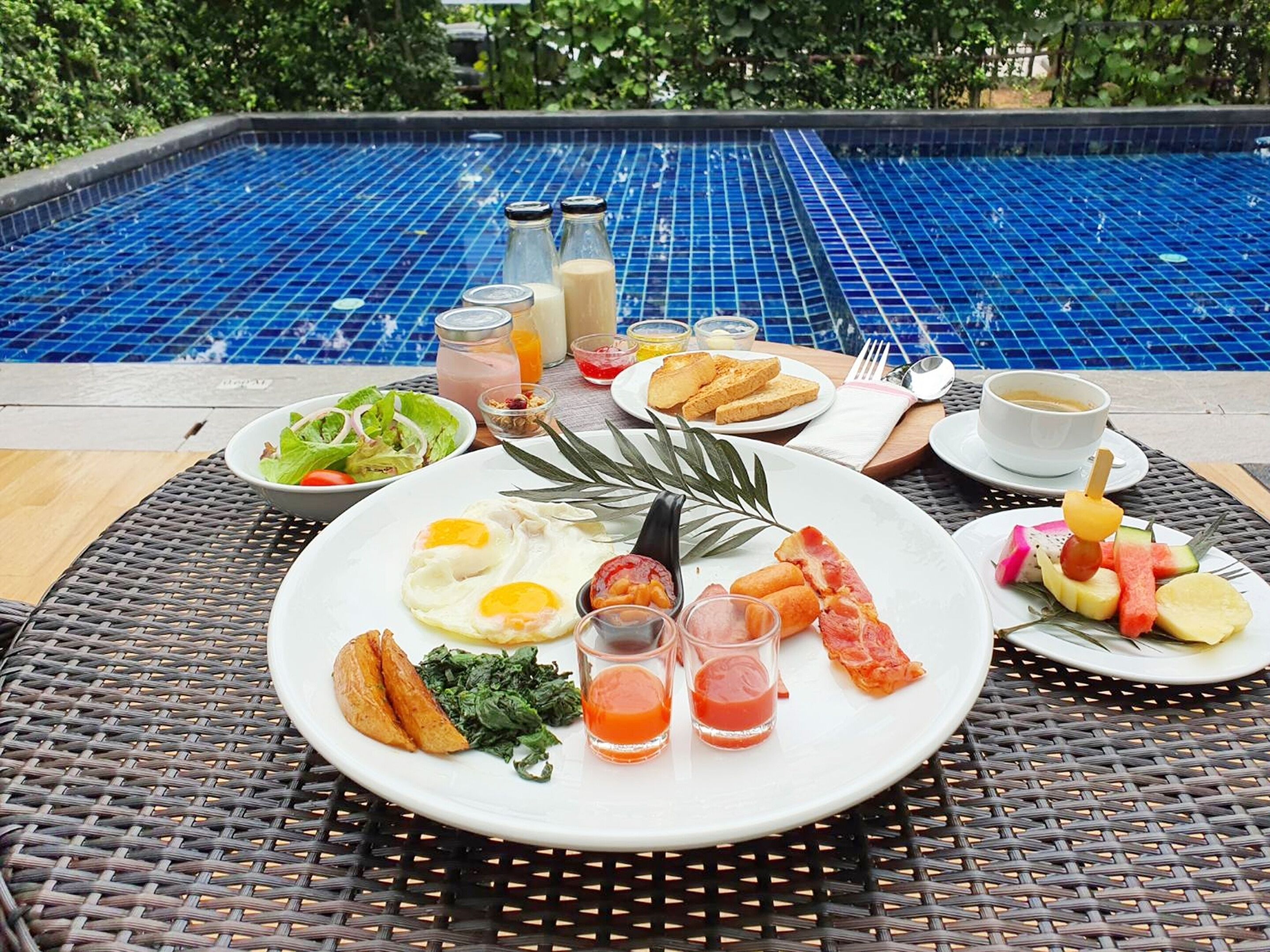 A breakfast setting with a pool in the background.