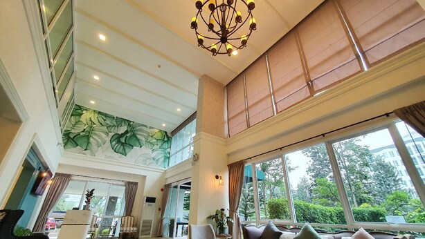 A spacious lobby with a checkered floor, a large chandelier, and a mural of leaves on the ceiling. - Fortune Courtyard Khao Yai Hotel Official (Pak Chong)