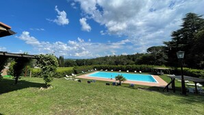 A swimming pool with lounge chairs and a pergola in a landscaped garden. - BigTypicalTuscan farmhouse, breath-taking views, big private outdoor, pool to share (Sarteano)
