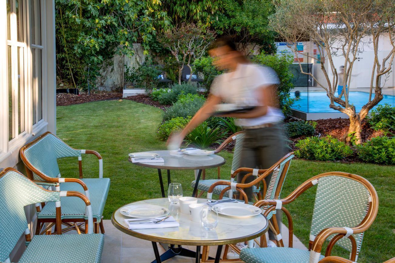 A patio with wicker furniture and a table set for dining.