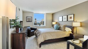 Een moderne hotelkamer met een groot bed, een bureau, een stoel, een bureaulamp en een plant in een pot.