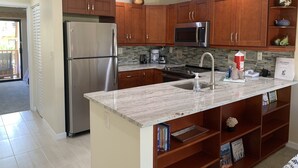Una cocina moderna con armarios de madera, electrodomésticos de acero inoxidable y encimera de mármol.