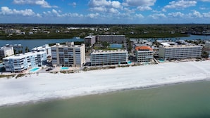 A coastal hotel with multiple buildings, a beach, and a marina.
