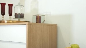 Ein kleiner Kühlschrank mit Glastür, der verschiedene Getränke und Obst enthält.