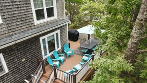 A deck with outdoor furniture, a grill, and a covered area.