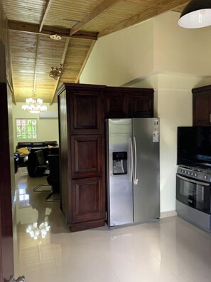 Kitchen area with refrigerator, oven, and television.