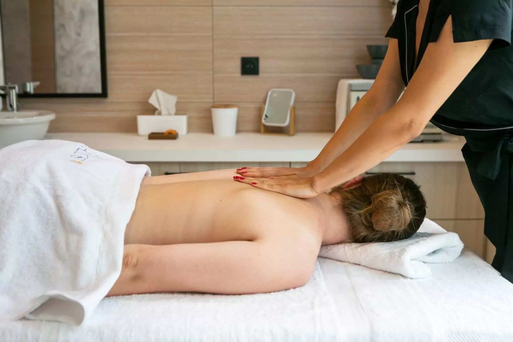 A massage therapy session in a modern spa setting with a clean, minimalist design.