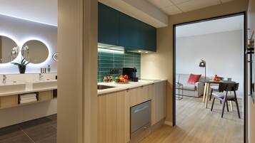 Una cocina moderna con lavavajillas, un comedor con mesa y sillas, y un sofá.
