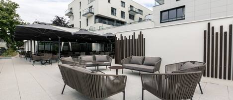 An outdoor seating area with modern furniture and a covered section.