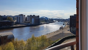 A river with a bridge and buildings in the background. - Swan Apartments - By Week2Week (Newcastle-upon-Tyne)