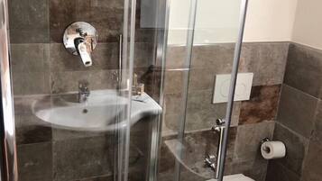 Ein modernes Badezimmer mit einer Glasdusche, einem Waschbecken und einer Toilette.