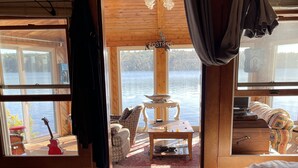 Una habitación de cabaña de madera con una cama, una mesa y vistas a un lago.