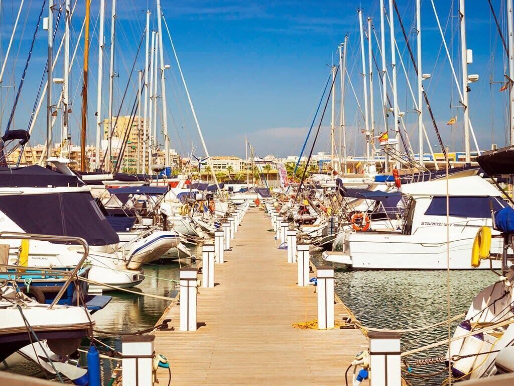 Uma marina com vários barcos atracados ao longo de um cais de madeira.