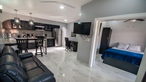 Eine moderne Wohnung mit Küche, Essbereich und Schlafzimmer.