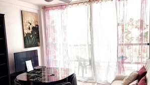 A living room with a round table, chairs, a sofa, a TV, and a painting on the wall. - Viña del Mar, ocean view (Costa Adeje)