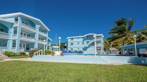 Un complexe hôtelier doté d’une piscine, de plusieurs bâtiments et d’une pelouse bien entretenue.