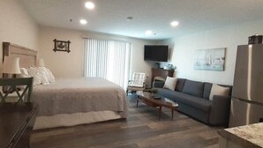 A compact living space with a bed, sofa, coffee table, and a TV. - Steps from Wells Beach, Bellevue by the Sea is perfect for your Maine vacation (Wells)