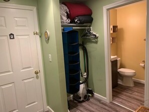 A compact bathroom with a toilet, a blue storage unit, and a vacuum cleaner. - ONE MINUTE WALK to WELLS BEACH, Bellevue by the Sea is your perfect vacation! (Wells)