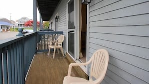 A covered porch with a wooden floor, two chairs, and a table. - ONE MINUTE WALK to WELLS BEACH, Bellevue by the Sea is your perfect vacation! (Wells)