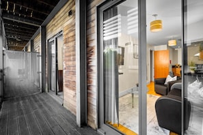 Ein modernes Interieur mit Holzfassade, großen Schiebegläsern und einer Sitzecke mit Sofa und Tisch.