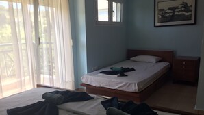 A bedroom with a bed, a nightstand, a window, and a painting on the wall.