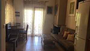 A living room with a sofa, TV, and a fireplace.