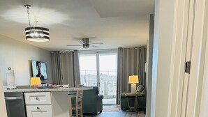 Une cuisine moderne avec un coin repas, un ventilateur de plafond et une vue dégagée sur l’extérieur grâce à une grande fenêtre.