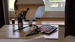 Une pièce dotée d’une grande fenêtre, d’un bureau en bois et d’un miroir.