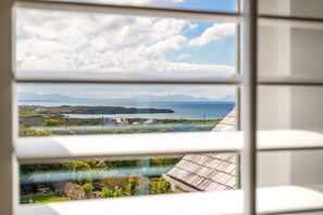 Une vue à travers une fenêtre, avec un ciel dégagé et un paysage lointain.