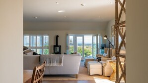 A spacious living area with a large sofa, a fireplace, and a view of the outdoors.