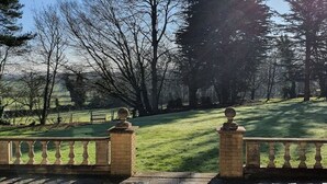 A stone pathway leading to a grassy area with a fence and trees in the background. - Historic Manor House - Sleeps 16 - Pool & Hot Tub (Rochester)