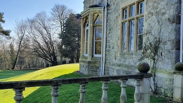 A stone building with a stone balcony and a grassy field in the background. - Historic Manor House - Sleeps 16 - Pool & Hot Tub (Rochester)