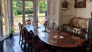 A dining room with a large wooden table, ornate chairs, and a chandelier. - Historic Manor House - Sleeps 16 - Pool & Hot Tub (Rochester)