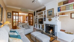 Una sala de estar con chimenea, estanterías y un sofá.